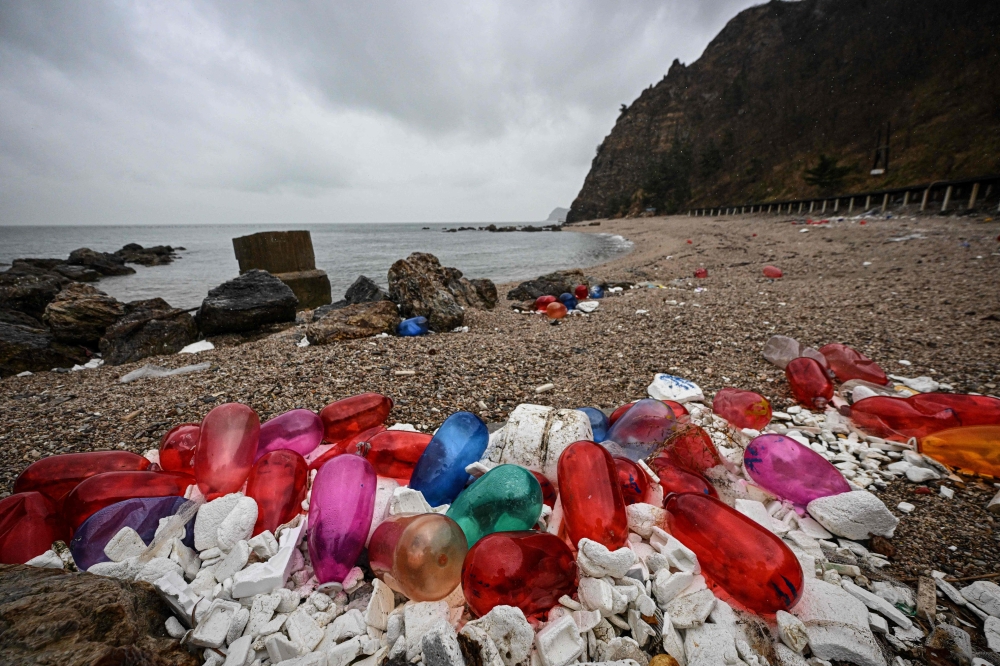 The photo taken on November 25, 2024 shows plastic fishing floats and other debris being washed up along the shore of the Miaodao archipelago in Yantai, in eastern China's Shandong province. (Photo by Jade Gao / AFP) 