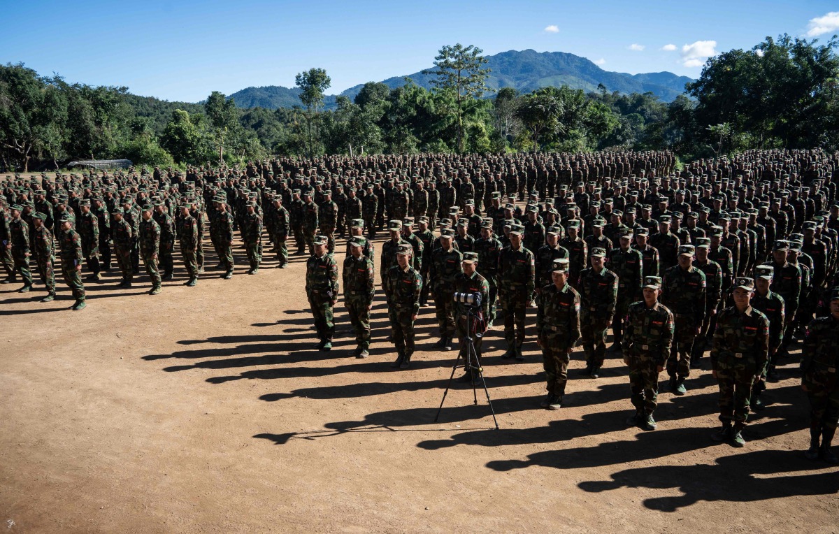 (FILES) This photo taken on November 9, 2024 shows members of Ta'ang National Liberation Army (TNLA) receiving military equipments at a graduation ceremony after getting special combat training for three months in a secret jungle near Namhkam, Myanmar's northern Shan State. (Photo by AFP)
