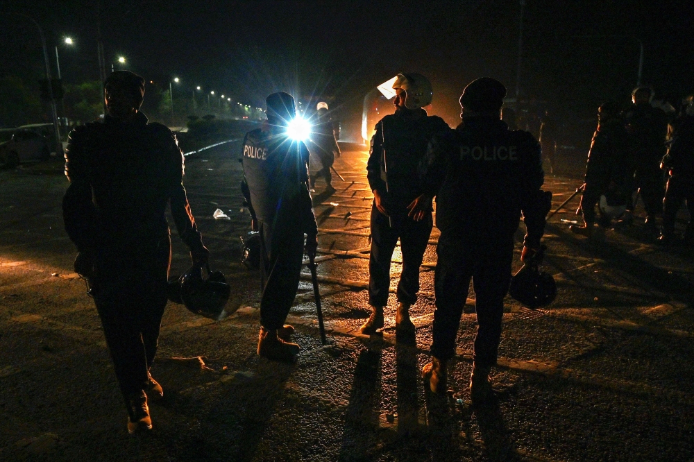 Policemen stand guard at the Red Zone area, early in Islamabad on November 27, 2024. (Photo by Aamir Qureshi / AFP)