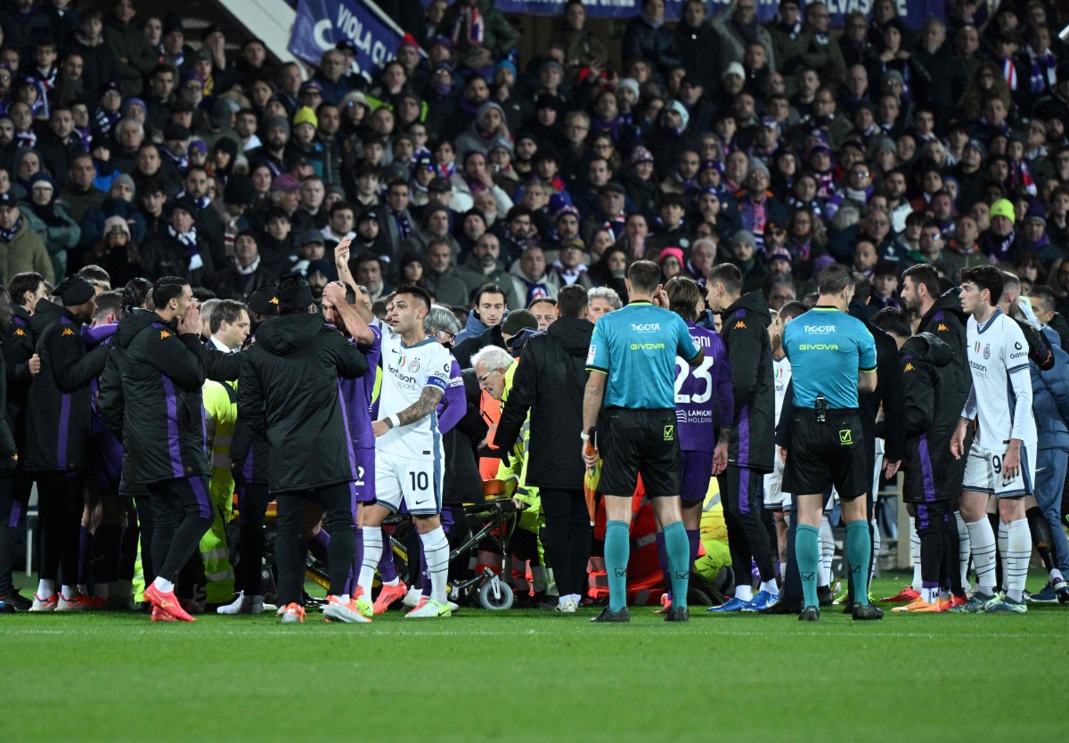 Fiorentina and Inter Milan players react as Fiorentina's Italian midfielder #04 Edoardo Bove receives medical attention after suddenly collapsing to the ground during the Serie A football match between Fiorentina and Inter Milan at the Artemio Franchi stadium in Florence on December 1, 2024. (Photo by TIZIANA FABI / AFP)
