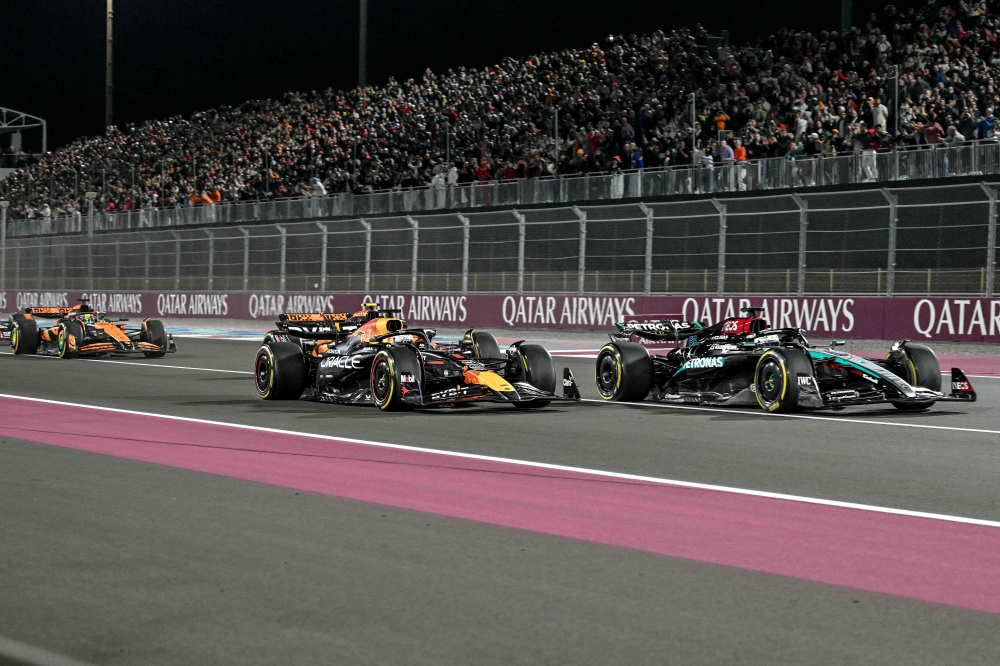 Mercedes' British driver George Russell, Red Bull Racing's Dutch driver Max Verstappen and McLaren's Australian driver Oscar Piastri compete during the Qatar Formula One Grand Prix at the Lusail International Circuit in Lusail, north of Doha, on December 1, 2024. (Photo by Andrej Isakovic / AFP)
 