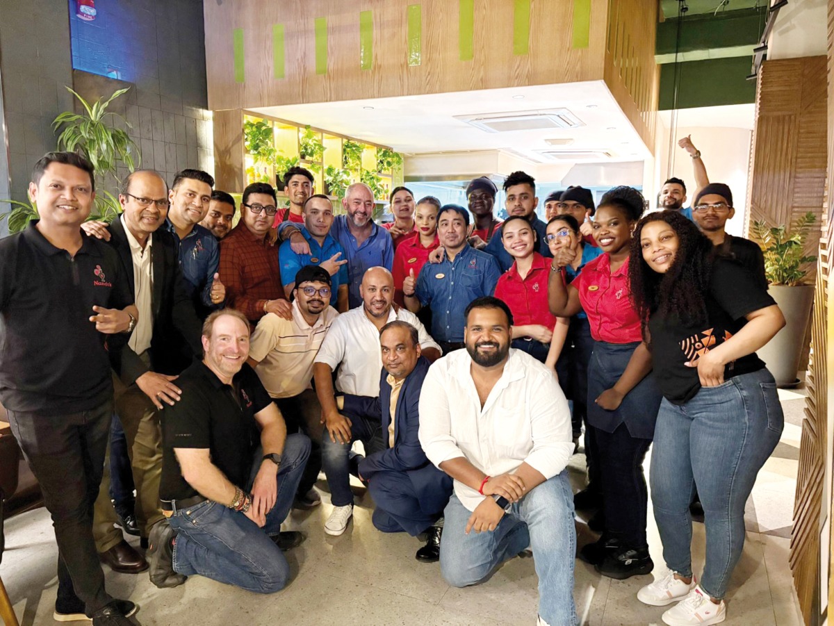 Nando’s co-founder Robbie Brozin, John Sikiotis (CEO of Nando’s Licensed Markets & India), and Vyanktesh Jaiswal (COO of Oryx Group for Food Services) pose for a group photo with the employees.