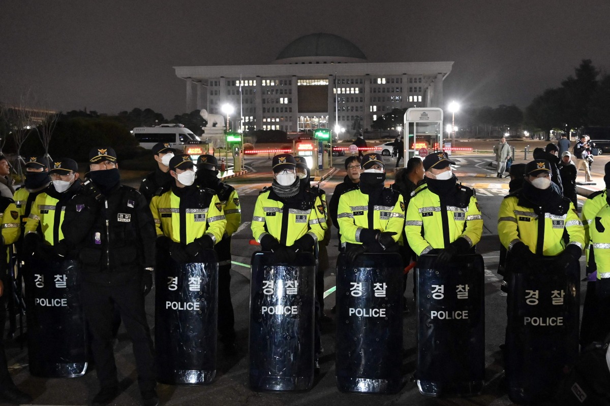 Police stand guard in front of the main gate of the National Assembly in Seoul on December 3, 2024, after South Korea's President Yoon Suk Yeol declared emergency martial law. Photo by Jung Yeon-je / AFP