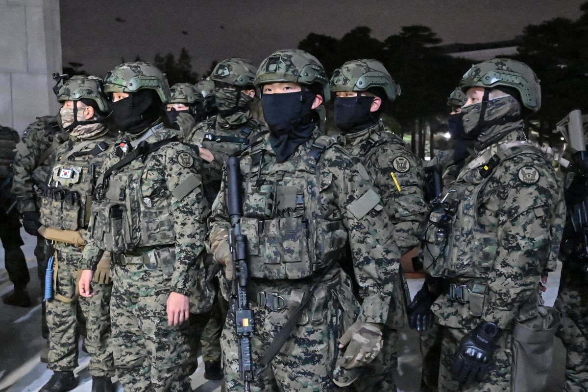 Soldiers try to enter the National Assembly building in Seoul on December 4 2024, after South Korea President Yoon Suk Yeol declared martial law. South Korea's President Yoon Suk Yeol on December 3 declared martial law, accusing the opposition of being 