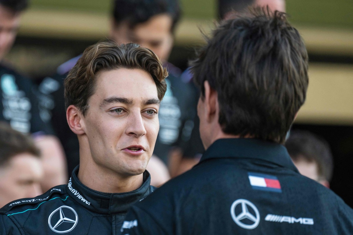 Mercedes' British driver George Russell speaks with Mercedes' Austrian team principal and CEO Toto Wolff as they arrive for a group photo with his team ahead of the Abu Dhabi Formula One Grand Prix at the Yas Marina Circuit in Abu Dhabi on December 5, 2024. (Photo by Andrej ISAKOVIC / AFP)