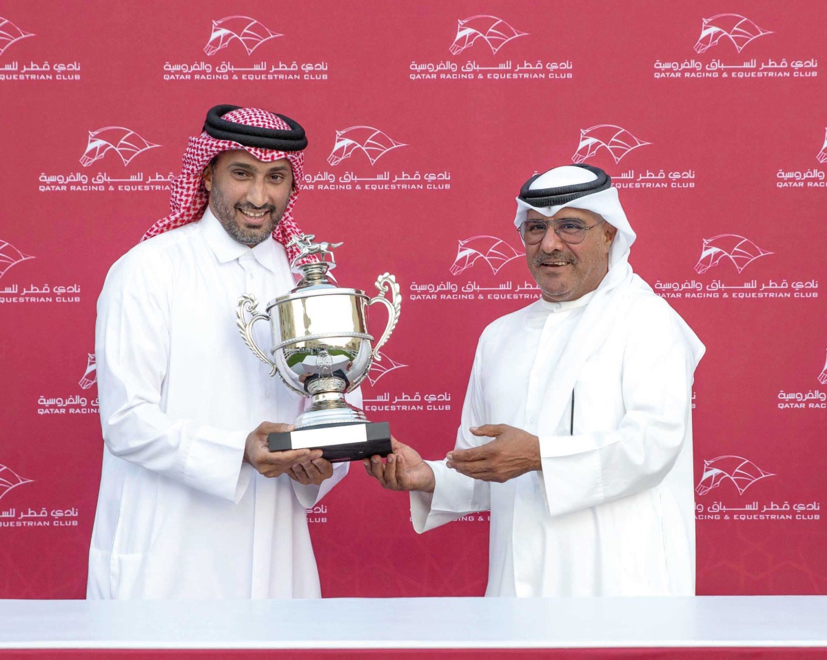 QREC Racing Manager Abdulla Rashid Al Kubaisi presents the trophy to representative of Wathnan Racing after Supercooled won the Thoroughbred Derby Trial.