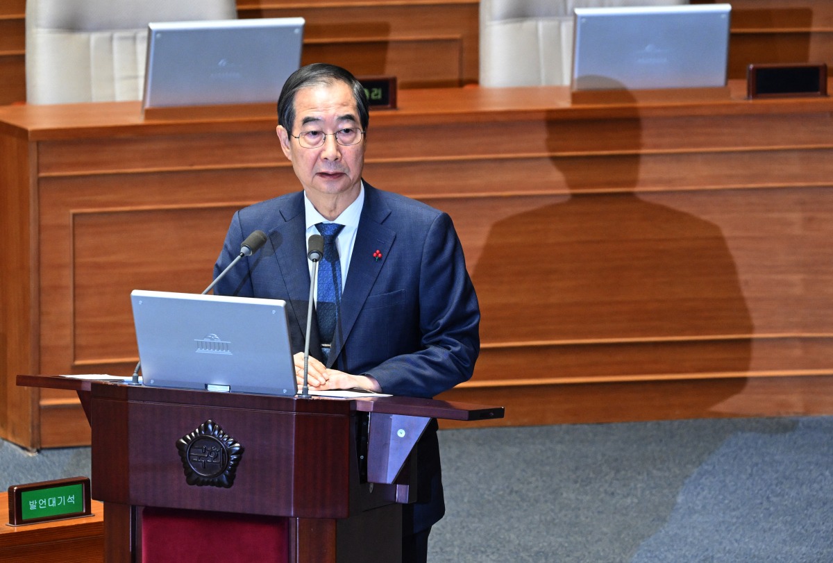 South Korean Prime Minister Han Duck-soo attends a plenary session, where a question-and-answer session was held relating to the martial law declaration, at the National Assembly in Seoul on December 11, 2024. South Korean police raided President Yoon Suk Yeol's office on December 11 as the investigation into his declaration of martial law gathered pace. (Photo by JUNG YEON-JE / AFP)