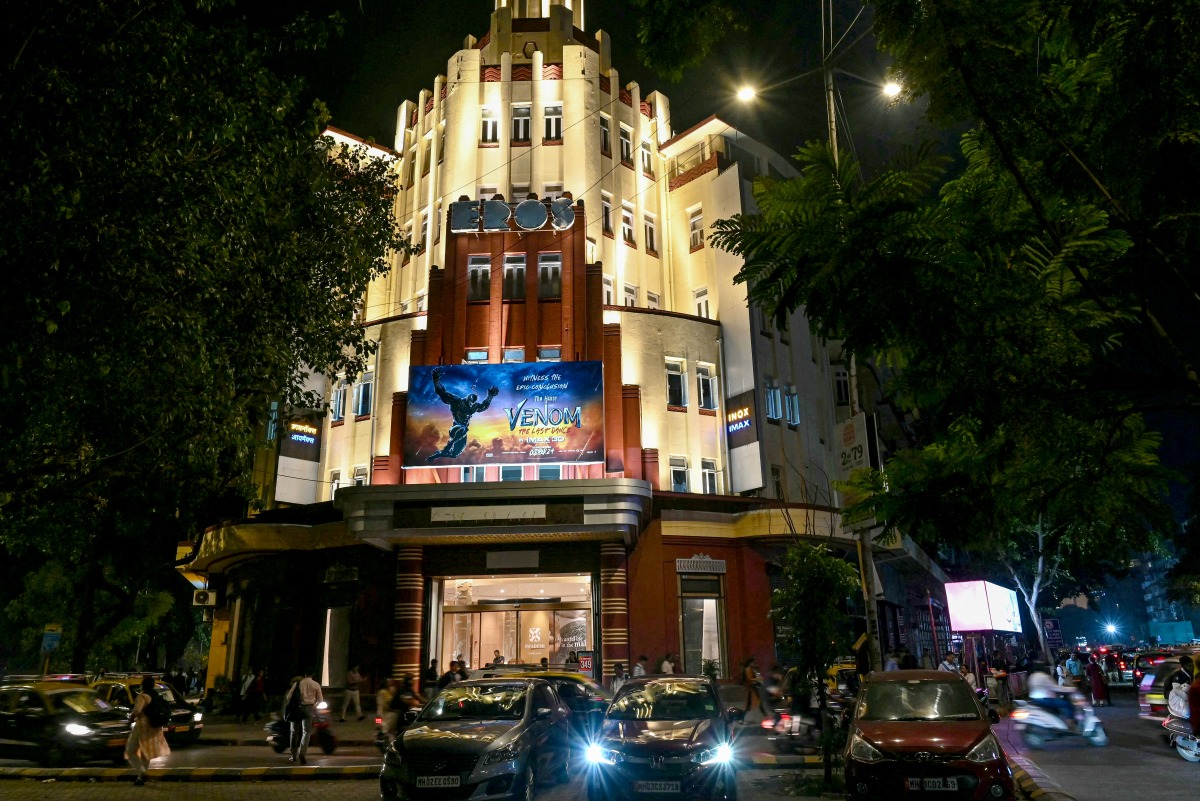 Pedestrians walk past the Eros Cinema, a UNESCO-designated Art Deco cinema theatre in the Cambata Building at Churchgate in Mumbai. (Photo by Indranil Mukherjee / AFP)
