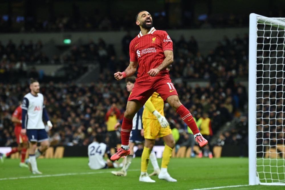 Liverpool's Egyptian striker #11 Mohamed Salah celebrates after scoring their fifth goal during the English Premier League football match between Tottenham Hotspur and Liverpool at the Tottenham Hotspur Stadium in London, on December 22, 2024. (Photo by Glyn Kirk / AFP)