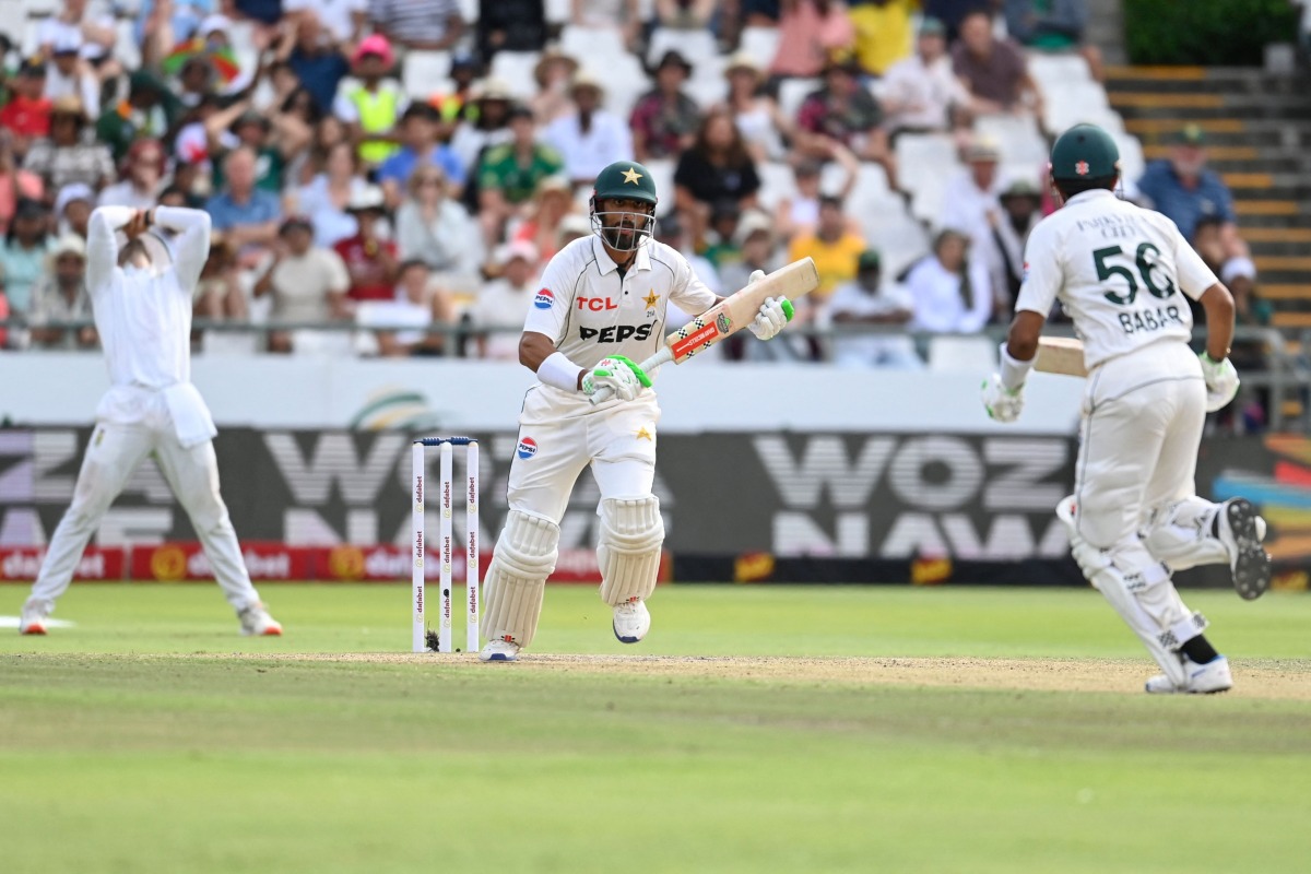 Pakistan's Shan Masood (C) and Pakistan's Babar Azam (R) run between the wickets during the third day of the second international Test cricket match between South Africa and Pakistan at Newlands stadium in Cape Town on January 5, 2025. (Photo by Rodger Bosch / AFP)
