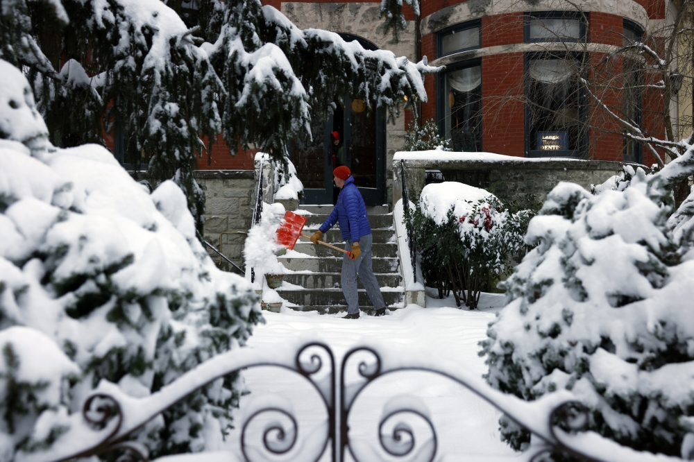 Langley Bowers shovels the snow off his stoop on Capitol Hill on January 6 as a major snowstorm blankets the city. (Photo by Robb Hill for The Washington Post)

