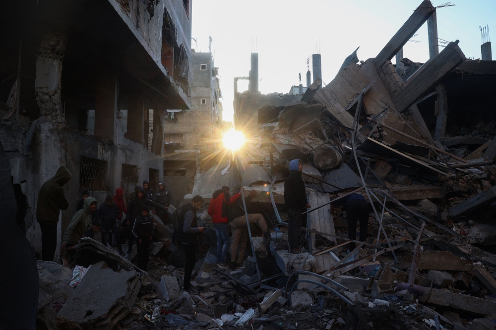 People search the rubble of a building destroyed in an Israeli strike on the Bureij camp for Palestinian refugees in the central Gaza Strip on January 8, 2025 as the war between Israel and the Palestinian Hamas movement continues. (Photo by Eyad Baba / AFP)