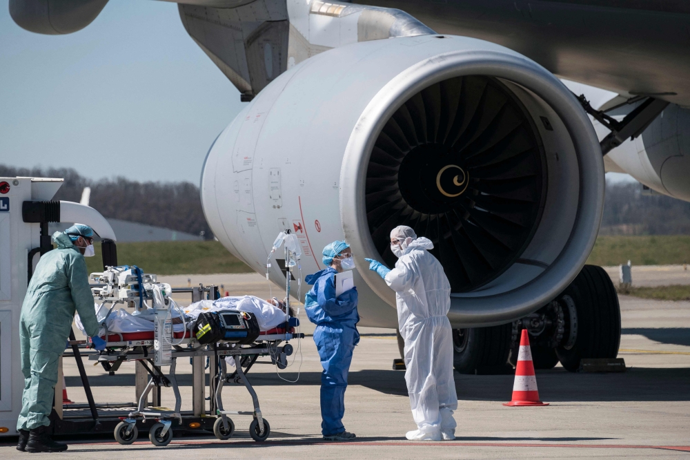 File: Medical staff embark a patient infected with the COVID-19 onboard a French air force medicalised Airbus A330 Phenix aircraft at the Bale-Mulhouse airport in France on March 31, 2020. (Photo by SEBASTIEN BOZON / AFP)