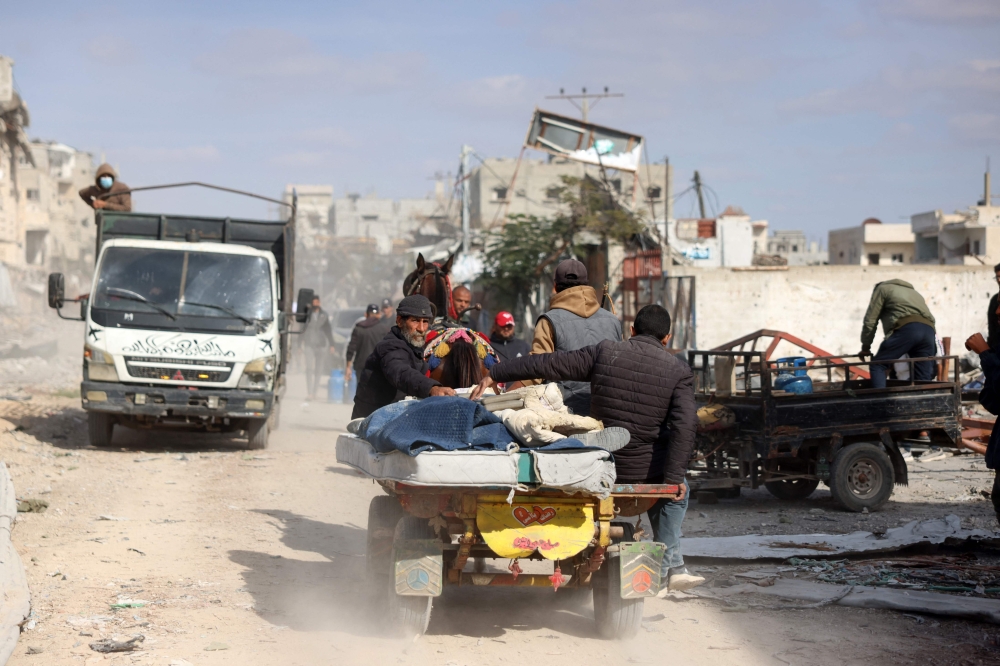 Displaced Palestinians transport their belongings as they return to central Rafah in the southern Gaza Strip on January 19, 2025. (Photo by Bashar Taleb / AFP)