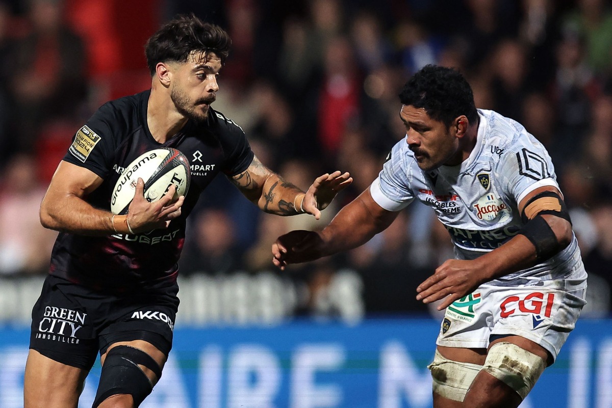 Toulouse's French fly-half Romain Ntamack (L) runs to evade Clermont's Samoan number eight Fritz Lee during the French Top14 rugby union match between Stade Toulousain Rugby (Toulouse) and ASM Clermont Auvergne at the Ernest-Wallon stadium in Toulouse, south-western France, on October 12, 2024. (Photo by Valentine CHAPUIS / AFP)

