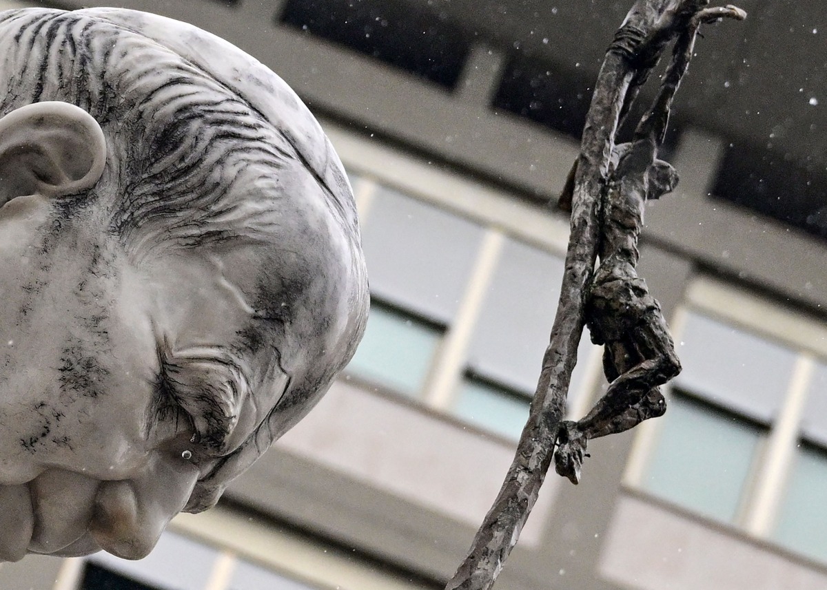 A picture shows the statue of John Paul II under heavy rain outside the Gemelli hospital where Pope Francis is hospitalized with pneumonia, in Rome on March 12, 2025. (Photo by Tiziana FABI / AFP)
