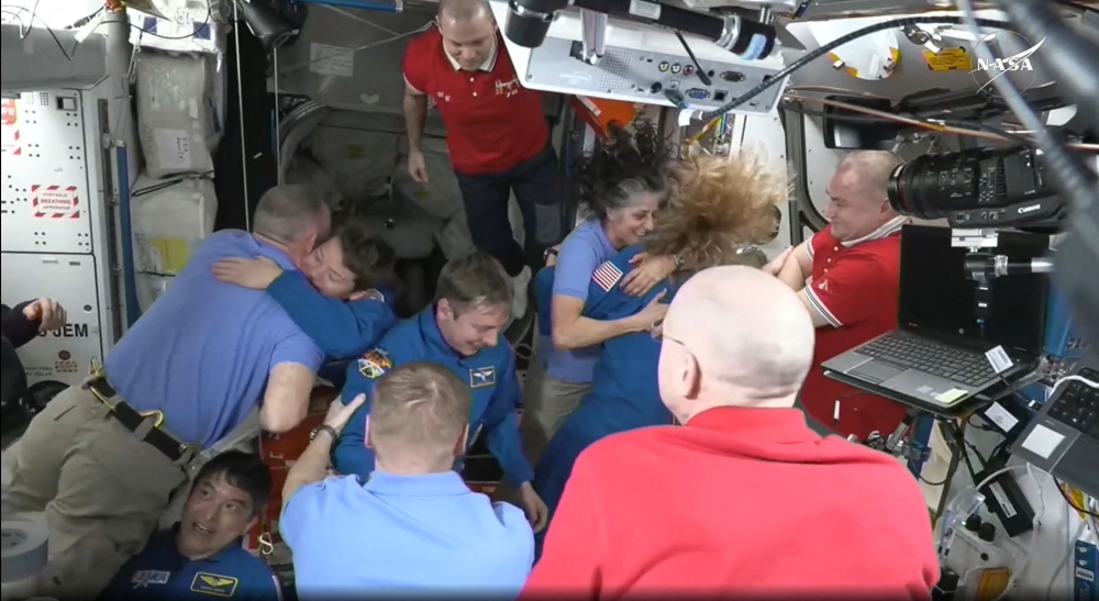 This screengrab made from a NASA livestream shows the SpaceX Dragon Crew-10 members, including NASA astronauts Anne McClain and Nichole Ayers, JAXA (Japan Aerospace Exploration Agency) astronaut Takuya Onishi, and Roscosmos cosmonaut Kirill Peskov, greeting International Space Station crew members including NASA astronauts Butch Wilmore (L) and Suni Williams (3R) on March 16, 2025. (Photo by NASA / AFP) 