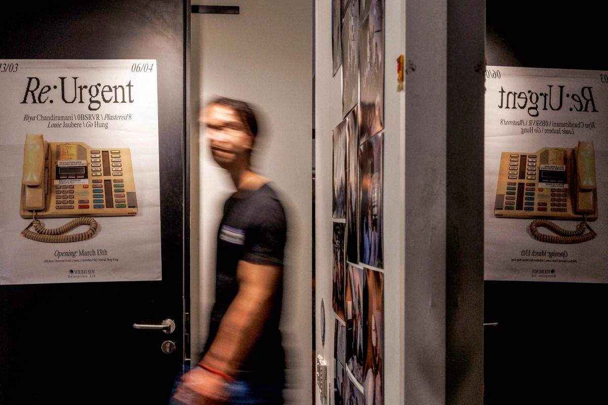 A visitor attends the opening of an exhibition titled 'RE:URGENT' by Young Soy Gallery with five Hong Kong artists including Go Hung, Louie Jaubere, OBSRVR, Plastered 8 and Riya Chandiramani, at a vacant office in Hong Kong on March 13, 2025. (Photo by May JAMES / AFP)