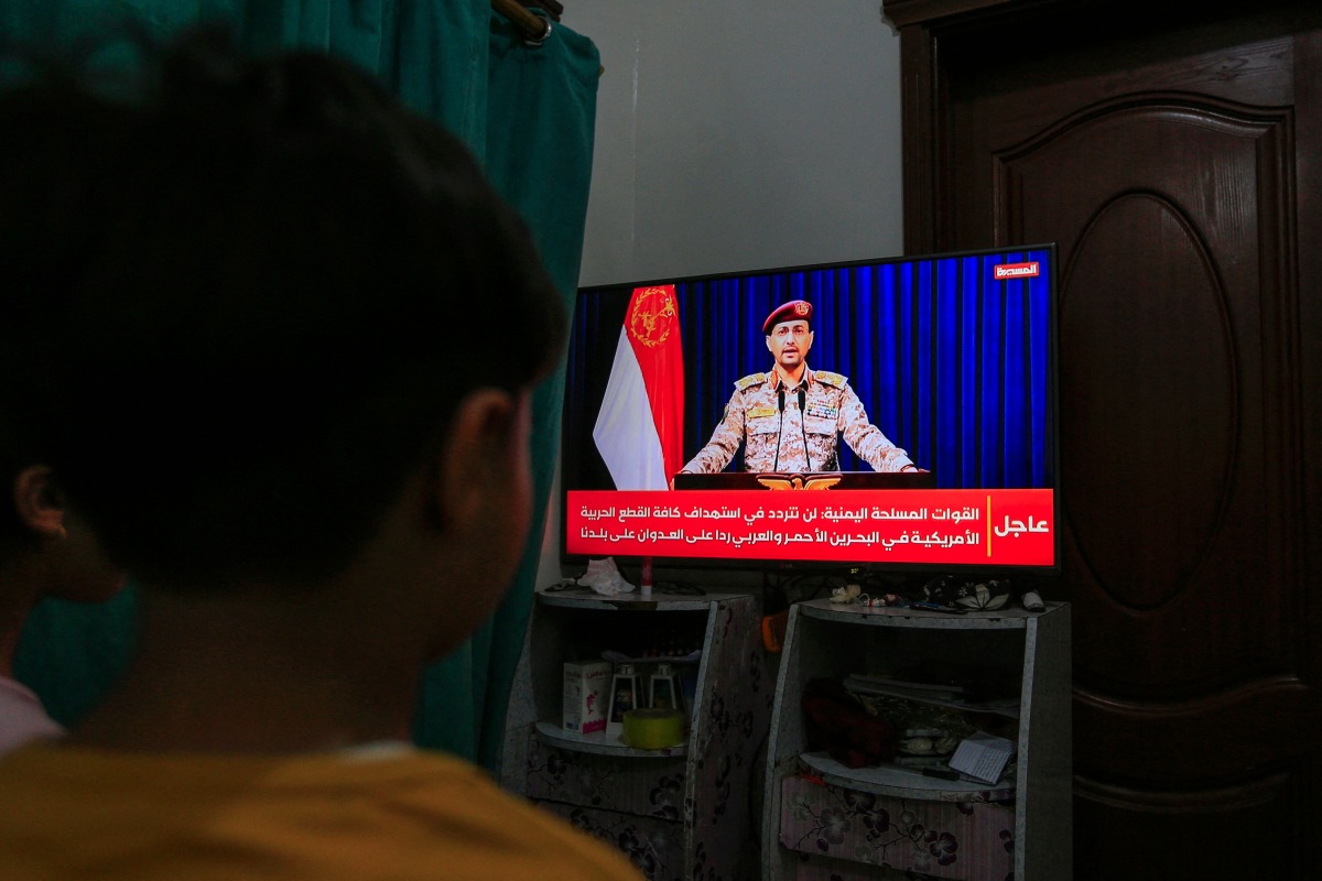 Yemenis in Sanaa watch a televised statement by the Houthi military spokesman Yahya Saree announcing the rebel group launched an attack on a US aircraft carrier in the Red Sea on March 16, 2025. (Photo by Mohammed HUWAIS / AFP)