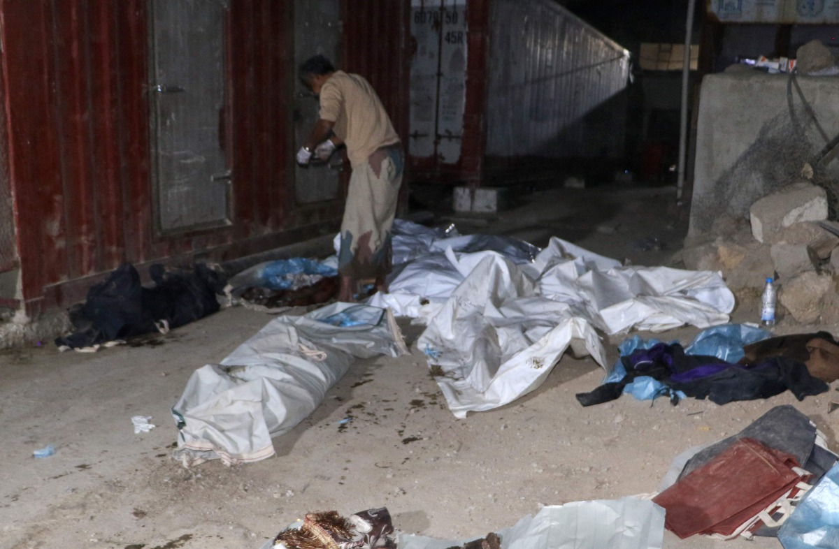 A man covers bodies of victims, including children, of a US airstrike in Yemen's northern Saada province, on March 16, 2025. (Photo by AFP)
