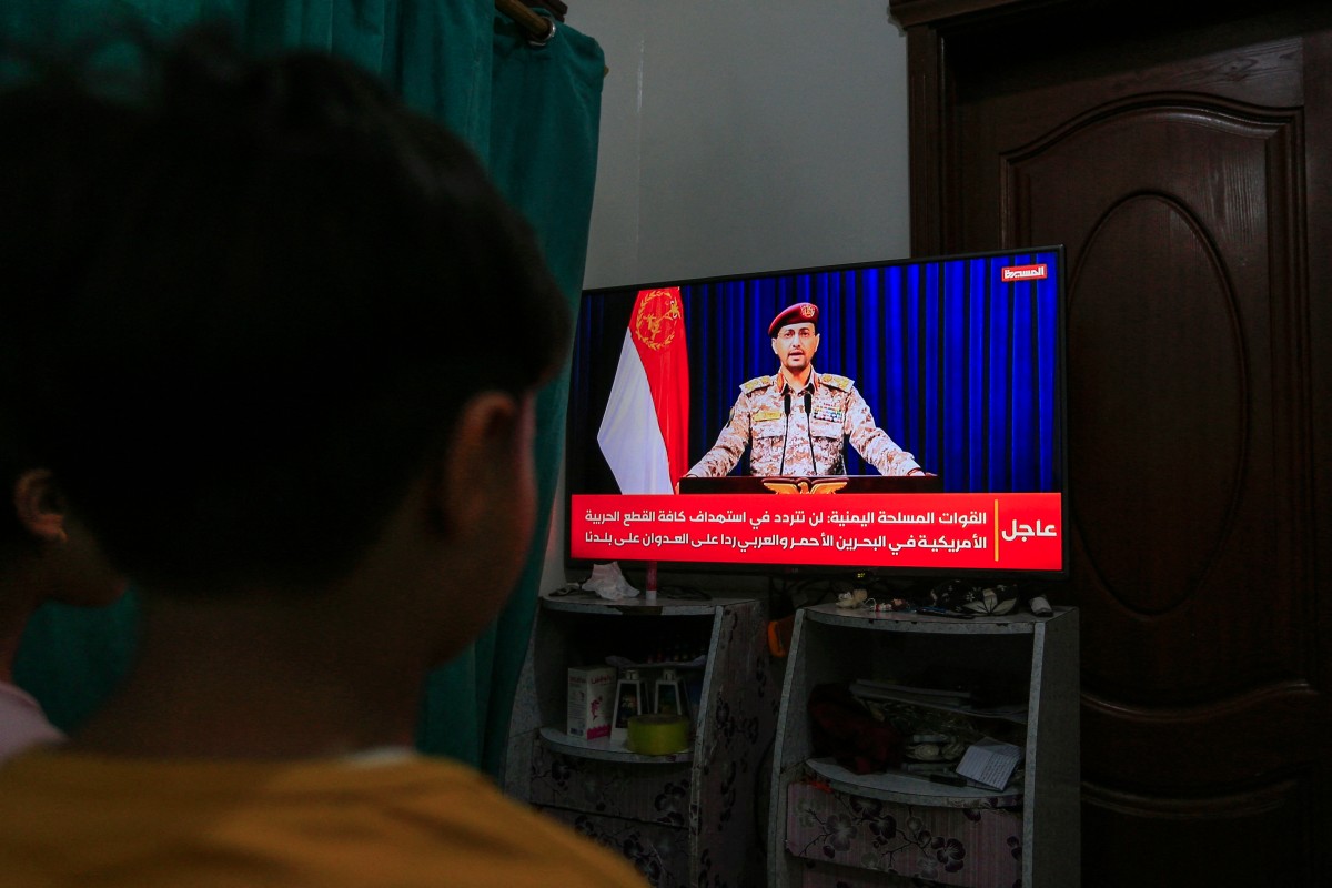 Yemenis in Sanaa watch a televised statement by the Huthi military spokesman Yahya Saree announcing the group launched an attack on a US aircraft carrier in the Red Sea on March 16, 2025. Photo by Mohammed HUWAIS / AFP.