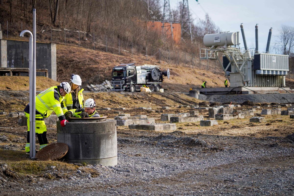 Representatives from a private company assisting with environmental consulting take water samples after several tons of oil leaked out in Baerum near Oslo, Norway, on March 17, 2025 following a break-in and damage to the Hamang transformer station this weekend. Photo by Ole Berg-Rusten / NTB / AFP