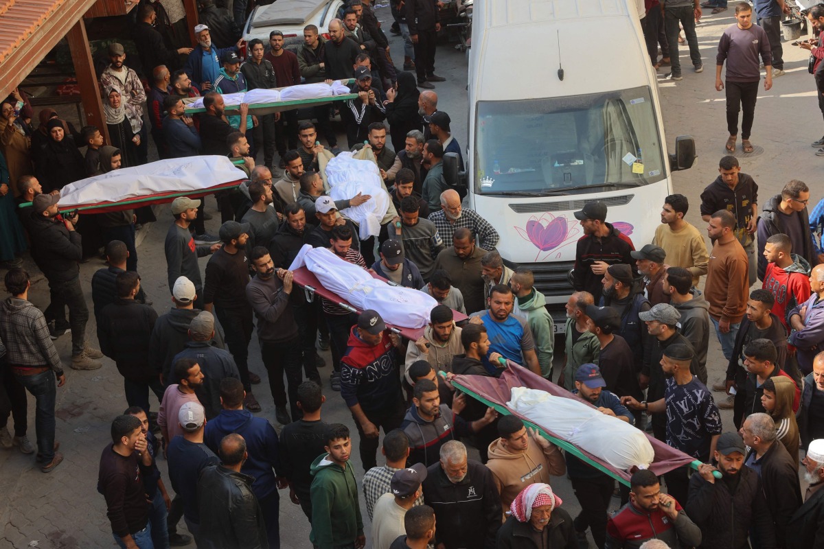 The bodies of victims killed in overnight Israeli airstrikes on the Gaza Strip are carried on stretchers at Al-Ahli Arab hospital, also known as the Baptist hospital, in Gaza City ahead of their burial on March 18, 2025. Photo by Omar AL-QATTAA / AFP