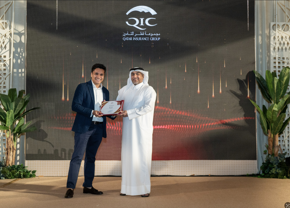 Group Chief Administrative Officer of QIC, Rashid Al Buainain honoring a longstanding employee during its annual service awards ceremony.