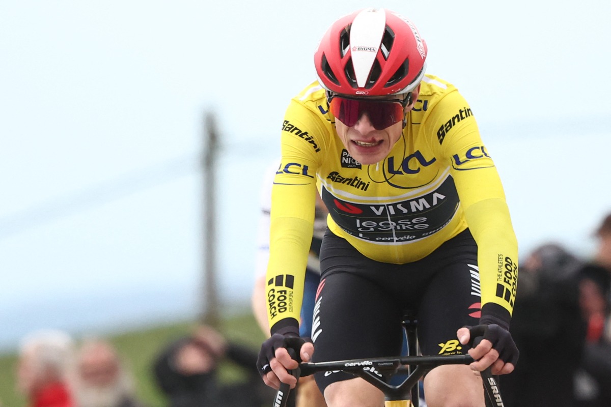 Team Visma-Lease a Bike's Danish rider Jonas Vingegaard wearing the overall leader's yellow jersey reacts as he crosses the finish line of the 5th stage of the Paris-Nice cycling race, 203,3 km between Saint-Just-en-Chevalet and La Côte-Saint-André, on March 13, 2025. Photo by Anne-Christine POUJOULAT / AFP