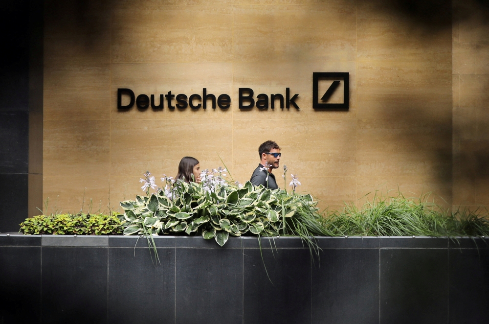 FILE PHOTO: People walk past a Deutsche Bank office in London, Britain July 8, 2019. REUTERS/Simon Dawson