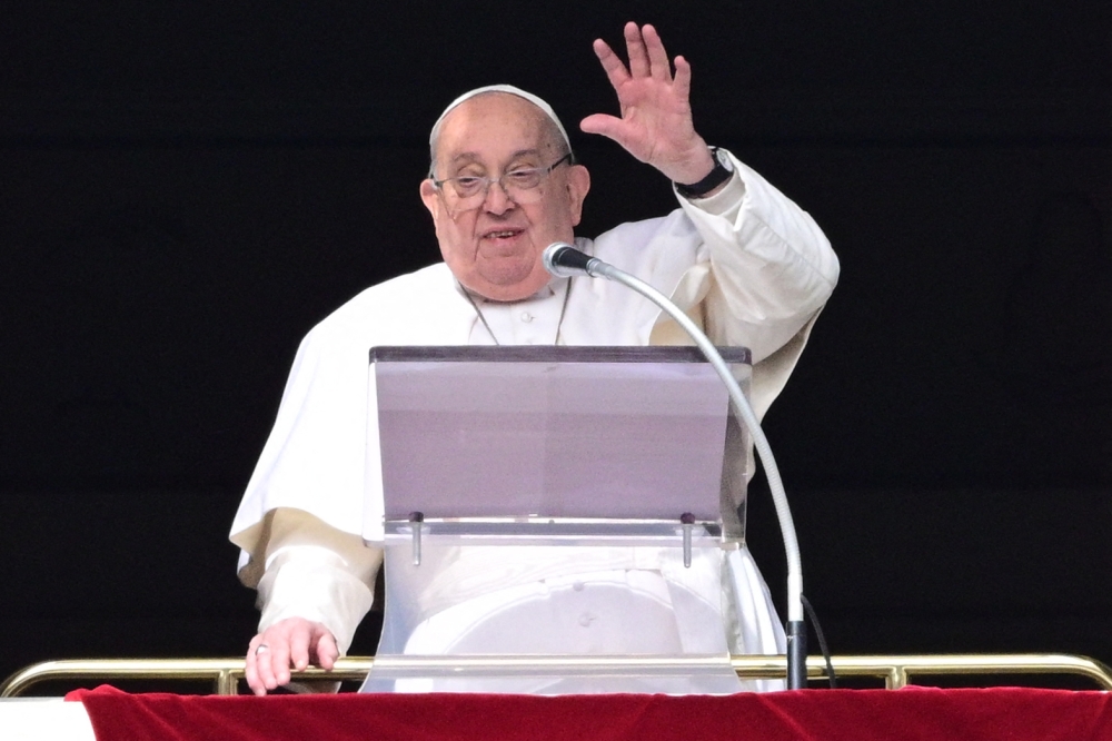 (Files) Pope Francis waves to the crowd from the window of the apostolic palace overlooking St. Peter's square during the Angelus prayer in The Vatican on February 2, 2025. (Photo by Tiziana FABI / AFP)