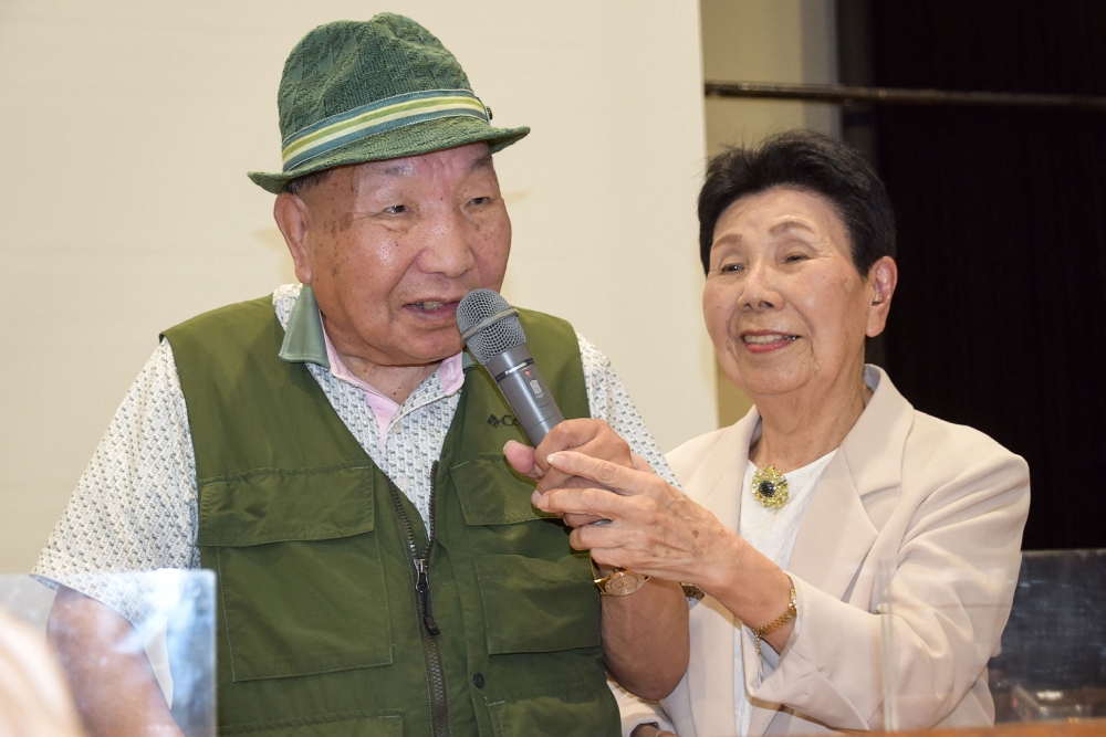 (Files) This photo taken on September 29, 2024 shows Iwao Hakamada (L) speaking as his then 91-year-old sister Hideko (R) holds the microphone during a judgement report session held by supporters in the city of Shizuoka, Shizuoka prefecture. (Photo by JIJI Press / AFP) 