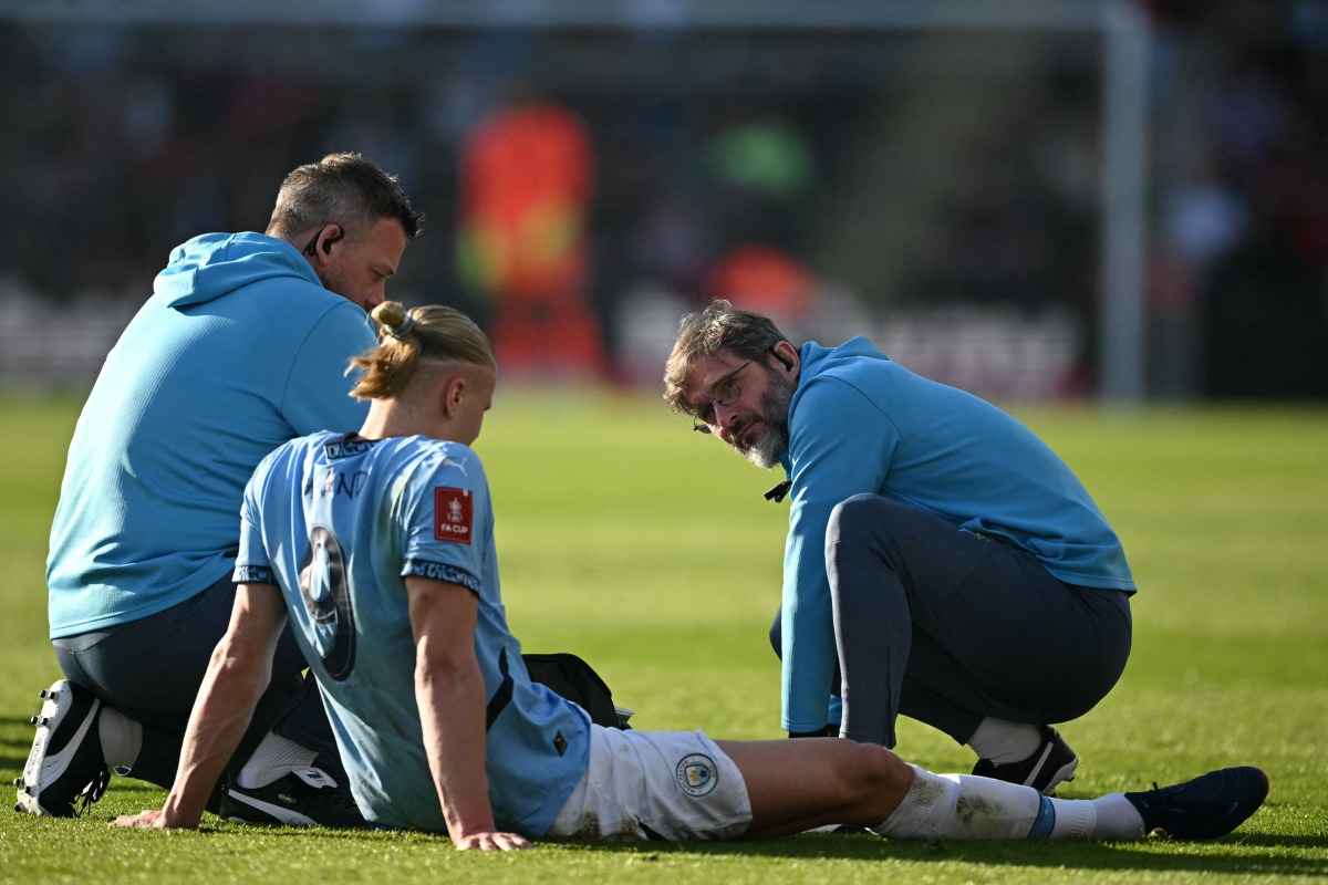 Manchester City's Norwegian striker #09 Erling Haaland receives medical attention after picking up an injury during the English FA Cup quarter-final football match between Bournemouth and Manchester City at the Vitality Stadium in Bournemouth, on the south coast of England on March 30, 2025. (Photo by JUSTIN TALLIS / AFP)