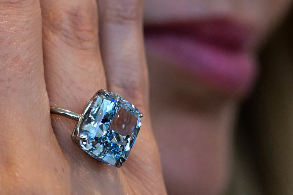 A Sotheby's employee displays the 10.03-carat 'Mediterranean Blue' diamond ring during a preview ahead of a public exhibition in Abu Dhabi on April 8, 2025. (Photo by Giuseppe Cacace / AFP)